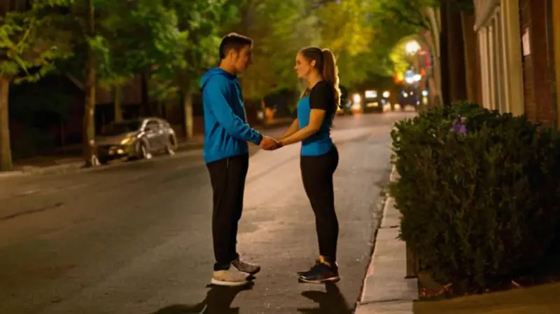 Pareja enérgica corre por calle iluminada